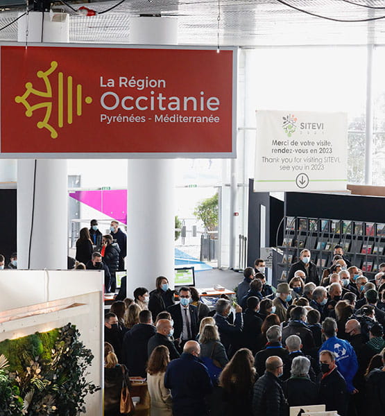 Panneau de la région Occitanie dans un hall avec des visiteurs