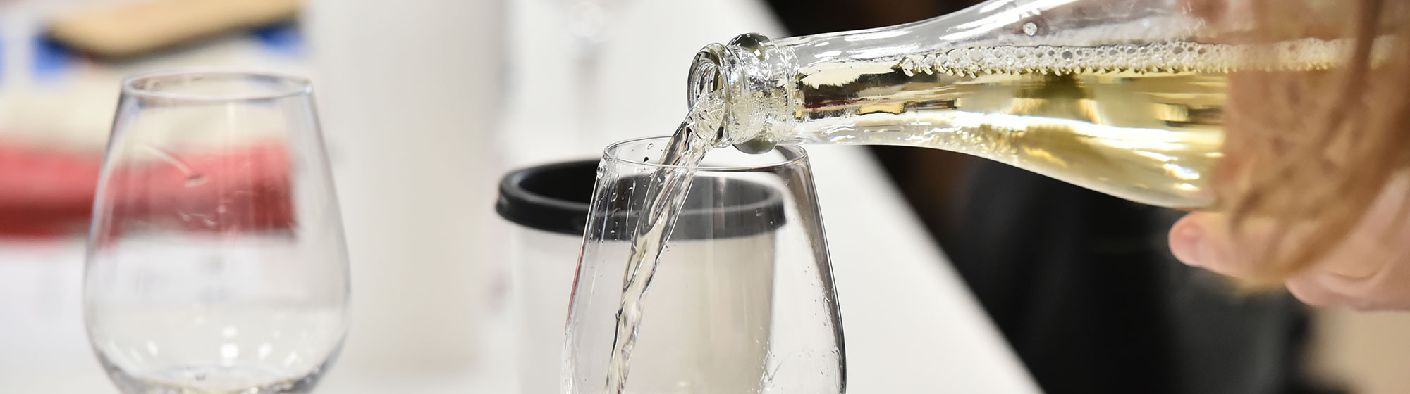 Woman pouring white wine into a glass